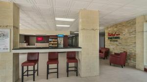 a lobby with a bar with stools and chairs at HomeTowne Studios by Red Roof Chicago - N Aurora-Naperville in North Aurora