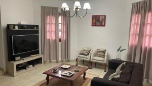 een woonkamer met een bank en een tv bij Casa Upcn in La Rioja