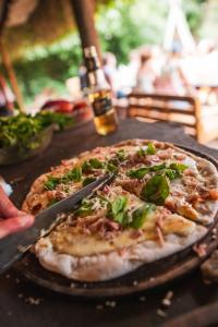 una pizza sentada sobre una mesa con un cuchillo en Wood Side Hostel en Mar del Plata
