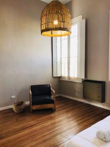 a room with a chair and a window and a chandelier at 1876 in Chivilcoy