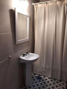 a bathroom with a sink and a shower curtain at 1876 in Chivilcoy