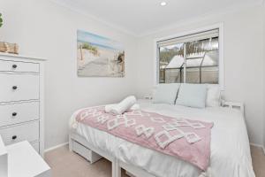 a white bedroom with a bed and a window at Collaroy Beachfront Hideaway - Parking and views in Collaroy
