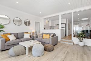 a living room with a couch and a table at Collaroy Beachfront Hideaway - Parking and views in Collaroy