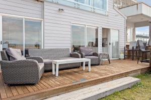 a patio with two couches and a table on a deck at Collaroy Beachfront Hideaway - Parking and views in Collaroy