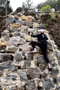 a man is sitting on a rocky hill at Rancho Ecológico El Mirador in Acajete