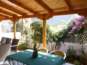 a green table and chairs under a wooden pergola at Villa in the sea Crete in Stavros