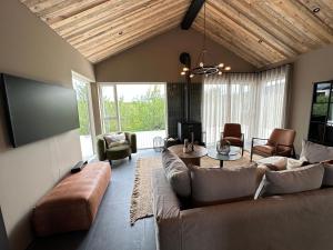 a living room with a couch and a table at Stunning Luxury Chalet in West Iceland in Reykholt