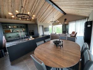 a dining room with a table and a kitchen at Stunning Luxury Chalet in West Iceland in Reykholt