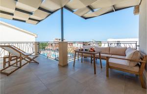 a balcony with a couch and a table at Gorgeous Home In Vrsi in Vrsi