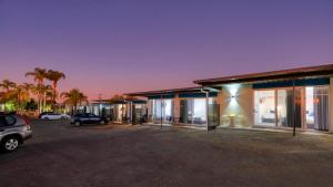 una casa con muchas ventanas y un estacionamiento en Hilltop Motel, en Broken Hill