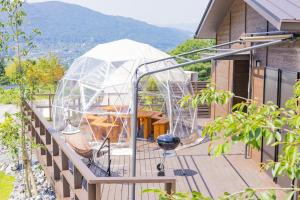 a greenhouse on the deck of a house at 由布院温泉グランピング　風の響き in Yufu