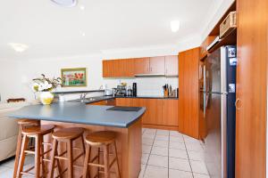 cocina con encimera azul y armarios de madera en Bella Vista, en Gerringong