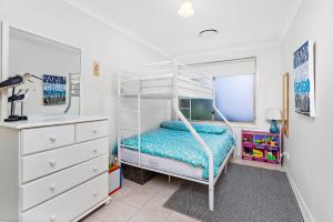 a bedroom with a bunk bed and a dresser at Bella Vista in Gerringong
