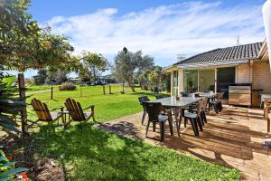 een patio met een tafel en stoelen in een tuin bij Bella Vista in Gerringong