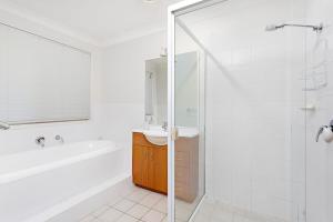 een badkamer met een bad, een wastafel en een douche bij Bella Vista in Gerringong