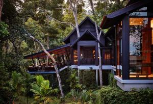 a house in the woods with a wrap around porch at The Ritz-Carlton, Langkawi in Pantai Kok