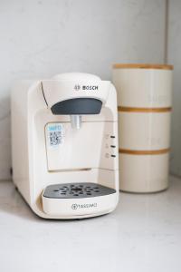 a toaster sitting on a counter next to two cups at Eden Grove - Islington - Studio Apartment in London