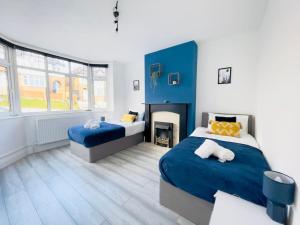 a bedroom with two beds and a fireplace at Central Luton 4 Bedroom home✪parking✪By Hostaguest in Luton