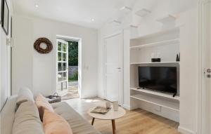 een witte woonkamer met een bank en een tv bij Amazing Home In Hornbk With Wifi in Hornbæk