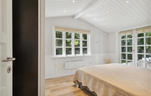 een slaapkamer met een bed en 2 ramen bij Amazing Home In Hornbk With Wifi in Hornbæk