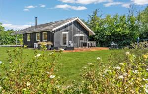 una casa negra con césped delante en Amazing Home In Sydals With Sauna, en Skovby