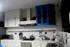 una cocina con armarios blancos y un armario azul en La Casa Central d' Ana - Departamento amoblado en Cajamarca