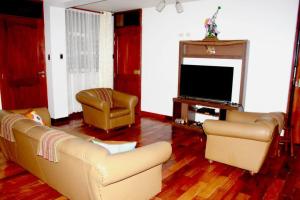 sala de estar con sofá y TV en La Casa Central d' Ana - Departamento amoblado en Cajamarca