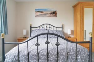 a bedroom with a bed with a black bed frame at Warm and Spacious 4BD Family Retreat with Garden in Plymouth