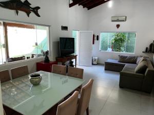 a living room with a table and a couch at Refugio Maresias, para 10 pessoas in Maresias