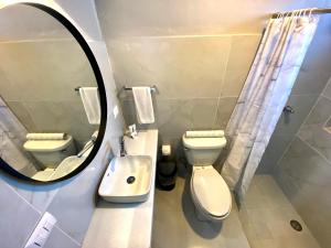 La salle de bains est pourvue de toilettes, d'un lavabo et d'un miroir. dans l'établissement Hotel El Pedregal, à Matehuala
