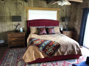 a bedroom with a bed and two night stands and a window at Rockin' B Ranch Bluff House in Pipe Creek