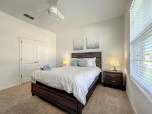 a white bedroom with a large bed and two lamps at 7 Bedroom 6 Bath Home with Private Pool Spa Walk to Solterra Clubhouse Lazy River 20 min from Disney in Davenport