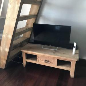a television sitting on a wooden table next to a staircase at Charmant T2 à Marina du Gosier in Le Gosier