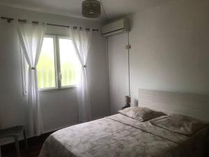 a bedroom with a bed and a window at Charmant T2 à Marina du Gosier in Le Gosier