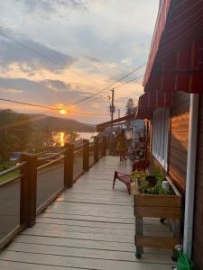 una pasarela de madera con una puesta de sol en el fondo en Chalet & Gîte Capitainerie du Passant, en Grandes-Piles