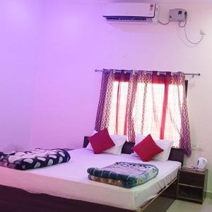 - 2 lits dans une chambre aux murs violets dans l'établissement The Mountain View Home Stay, à Khajurâho