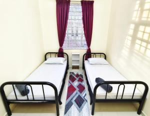 two beds in a small room with a window at Ujana Damai - Cosy 5 bedrooms near UMT UNISZA in Kuala Terengganu