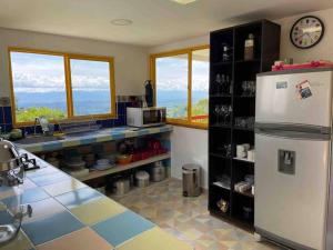 uma cozinha com um frigorífico e um balcão com janelas em Finca Las Veraneras en Sevilla Valle em Sevilla