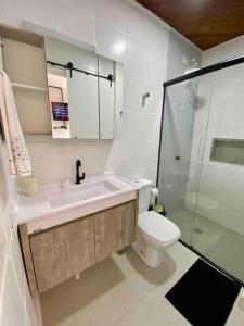uma casa de banho com um lavatório, um WC e um chuveiro em Canas303 - Apartamento próximo a praia na avenida principal em Florianópolis
