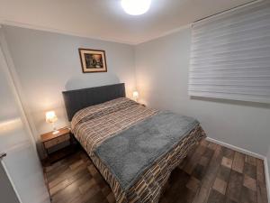 ein kleines Schlafzimmer mit einem Bett und einem Fenster in der Unterkunft CÓMODO Y RENOVADO DEPARTAMENTO CON VISTA AL MAR in Arica