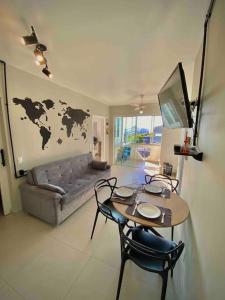 uma sala de estar com uma mesa e um sofá em Canas303 - Apartamento próximo a praia na avenida principal em Florianópolis