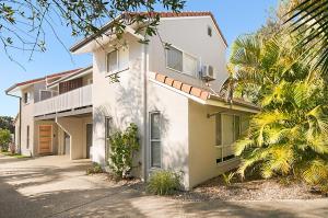 a white house with palm trees in front of it at Shivas@Byron... minutes walk to Main Beach! in Byron Bay