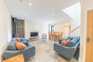 a living room with two blue couches and a table at No 2 The Coach House in Carnforth
