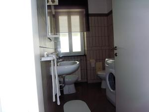 a small bathroom with a sink and a toilet at La Zucca a Pois in Formia