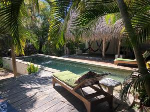una silla junto a una piscina con hamaca en Casitas Eclecticas, en Sayulita