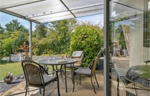 patio con mesa, sillas y ventana en Amazing Home In Bog By With Kitchen, en Bogø By