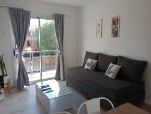 ein Wohnzimmer mit einem Sofa und einem großen Fenster in der Unterkunft DEPARTAMENTOS LEMOS TRES in Mendoza