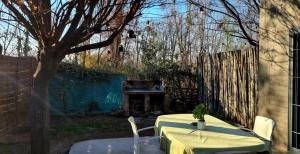 a table and chairs in a backyard with a piano at Departamento completo in Ciudad Lujan de Cuyo