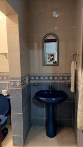 La salle de bains est pourvue d'un lavabo bleu et d'un miroir. dans l'établissement Hotel Morada de los Angeles, à Calera Víctor Rosales