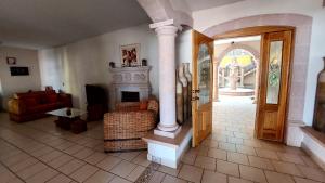 - un salon avec une cheminée et une porte ouverte dans l'établissement Hotel Morada de los Angeles, à Calera Víctor Rosales